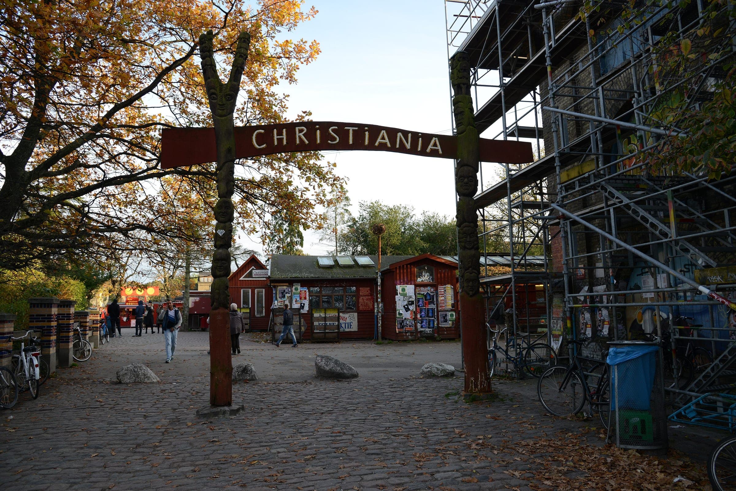 A carved wooden arch marks the main gate into Christiania from Prinsessegade in Copenhagen.