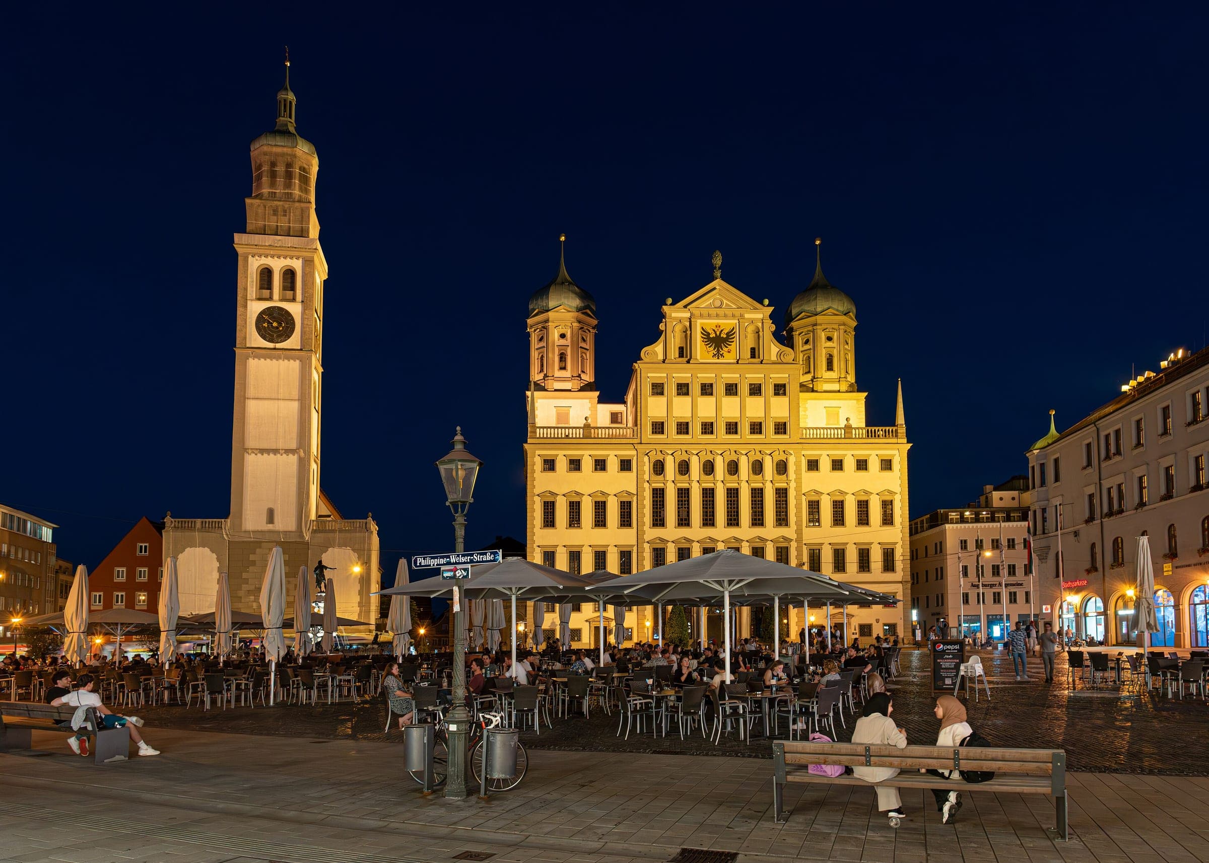 Augsburg's floodlit town hall and Perlach Tower stand over Rathausplatz on a clear night.