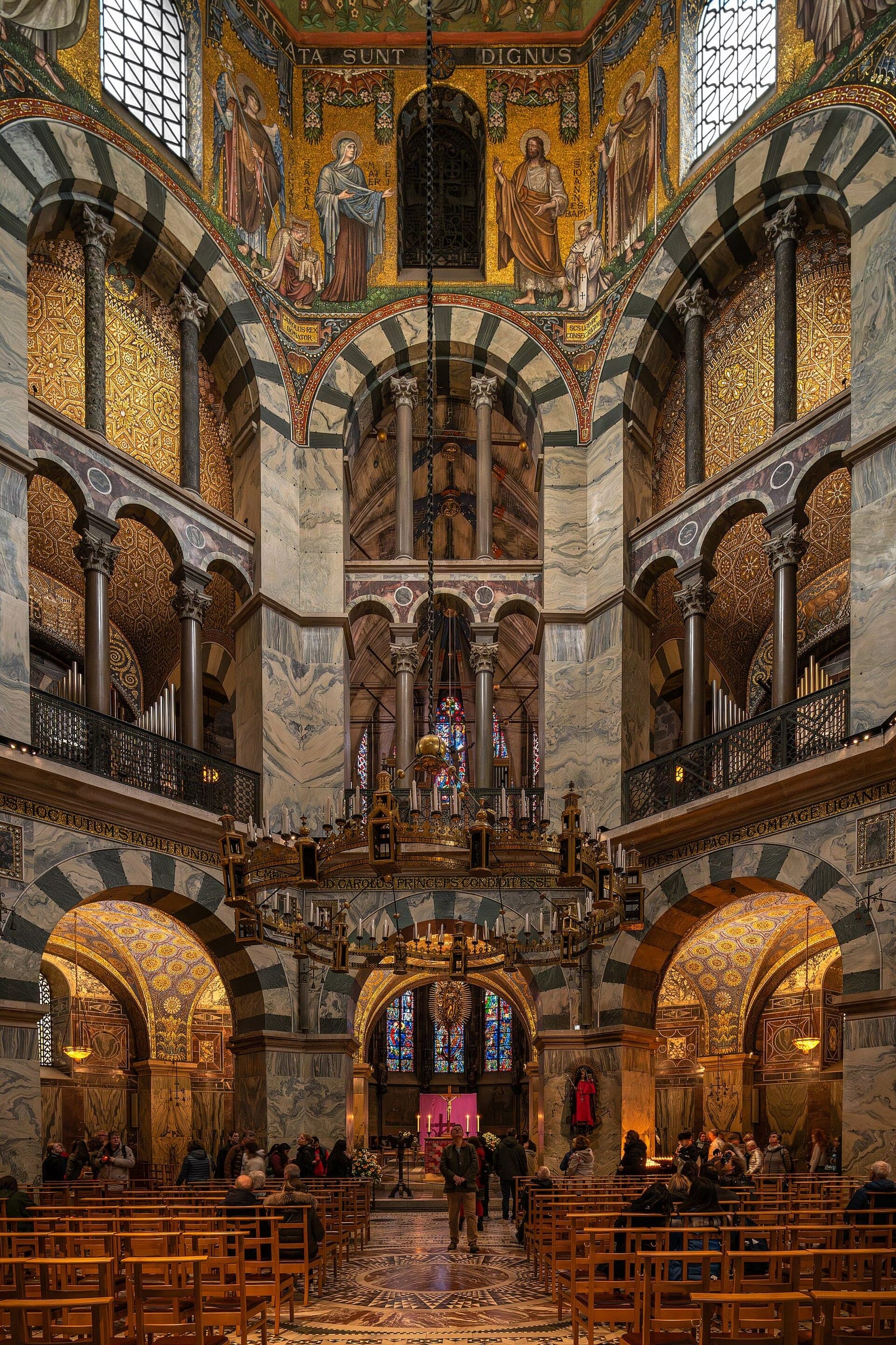 Gold mosaics and striped arches rise above the Barbarossa chandelier in the octagon of Aachen Cathedral